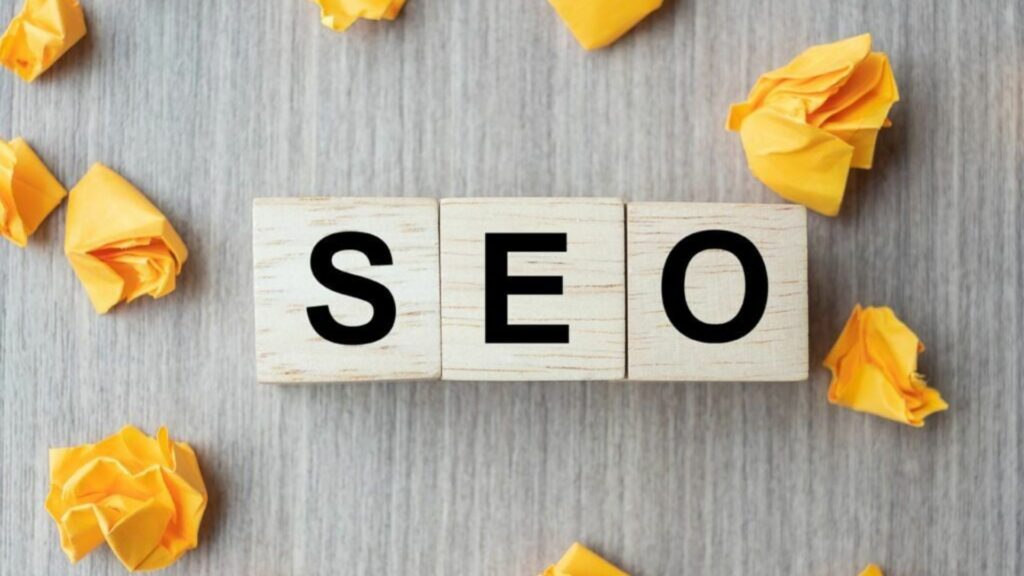 Yellow Folded Pieces of Paper Dotted Around the Words SEO